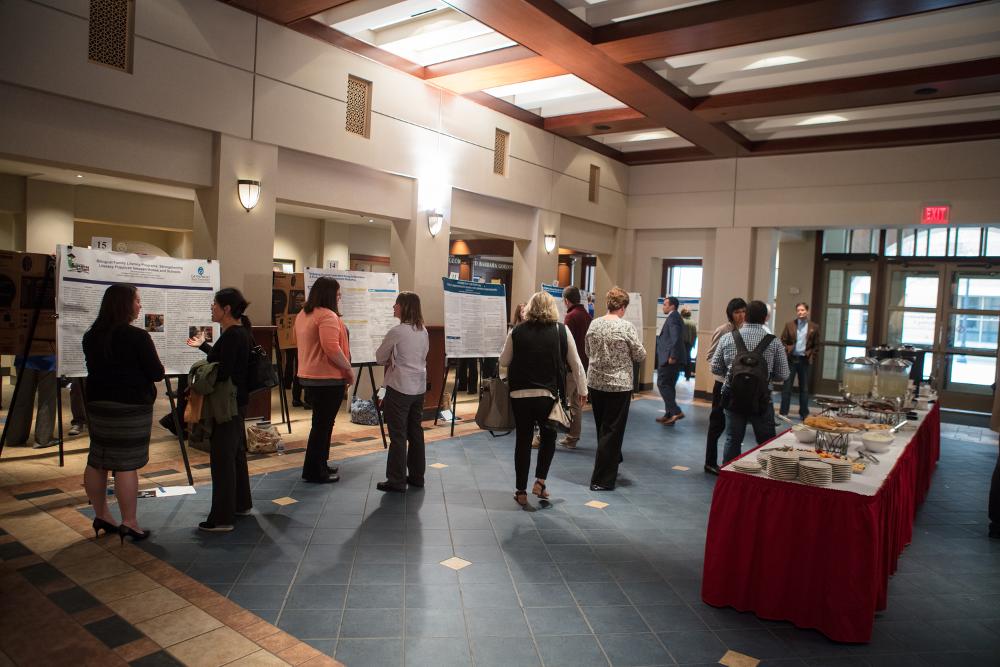 The Graduate Showcase, with many student posters, a buffet table, and people movng around the room